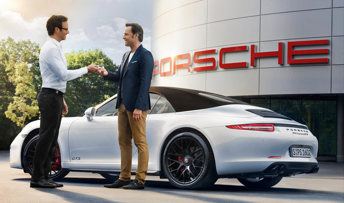 Image of a trusted Porsche salesperson interacting with a customer.