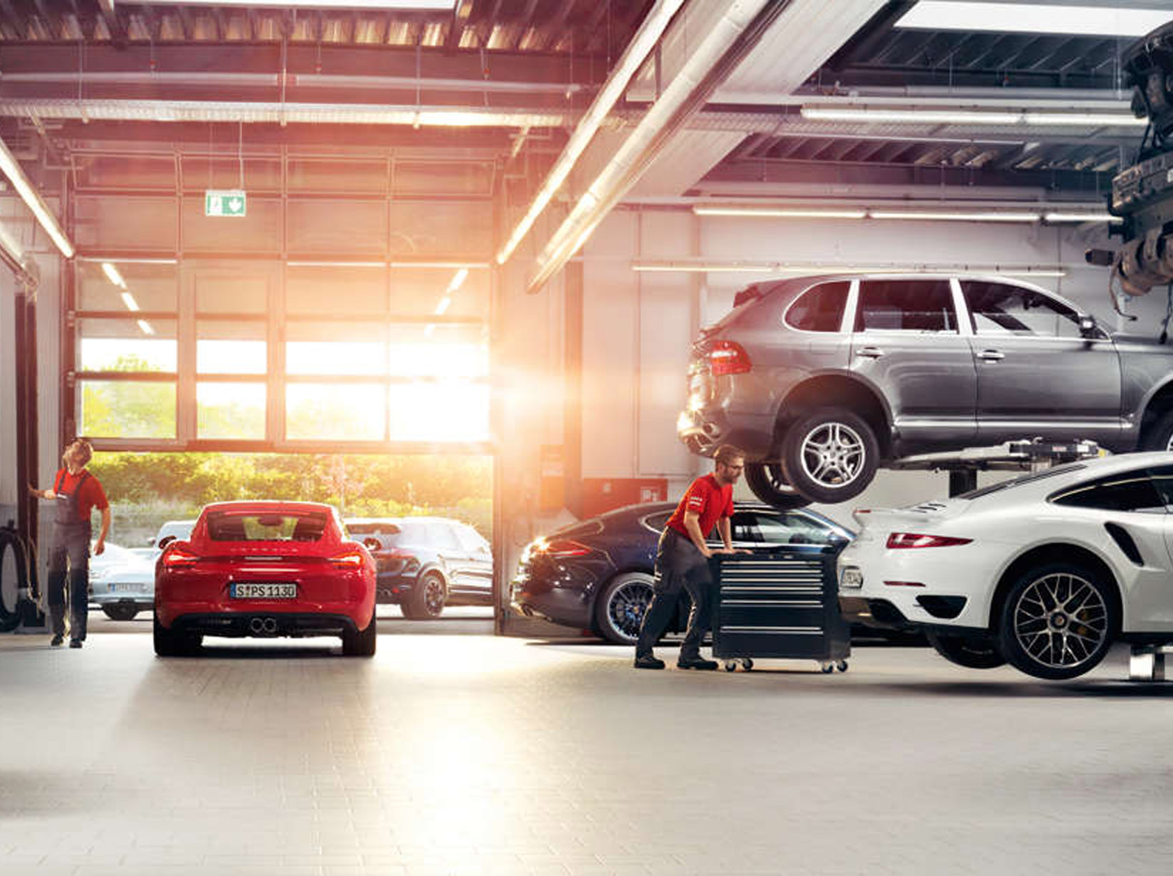 Image of Porsche service bay with multiple cars on lifts.